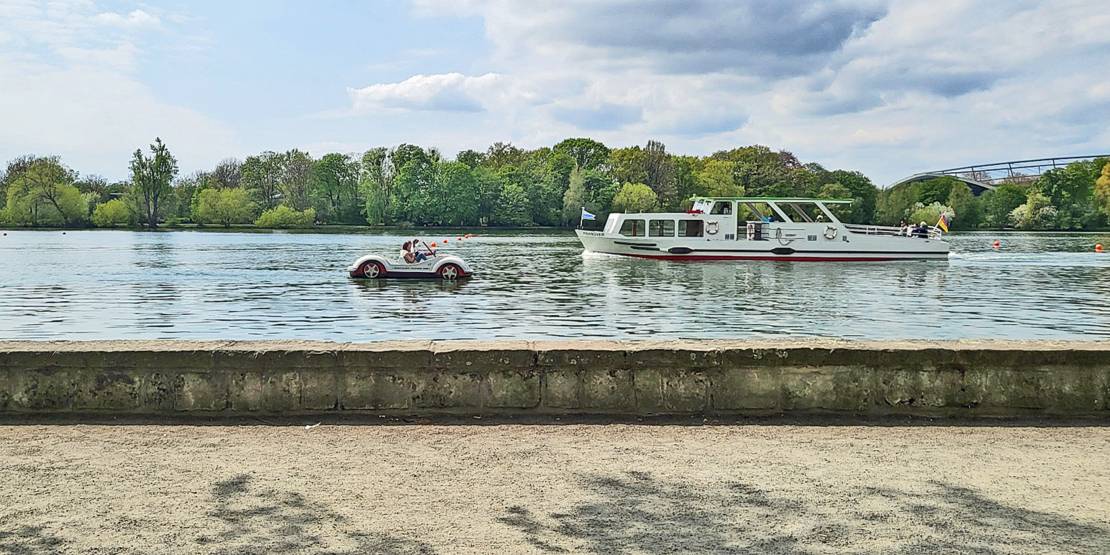 Eine Tretboot und ein Linienboot begegnen sich auf dem Maschsee.